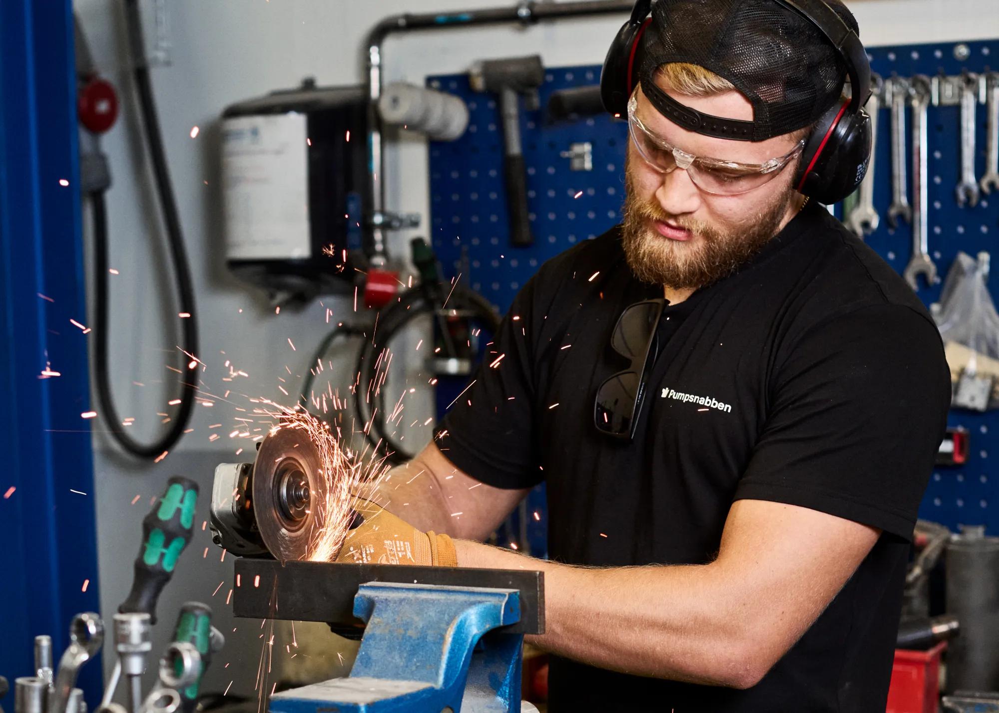 Arbetare som använder en slipmaskin