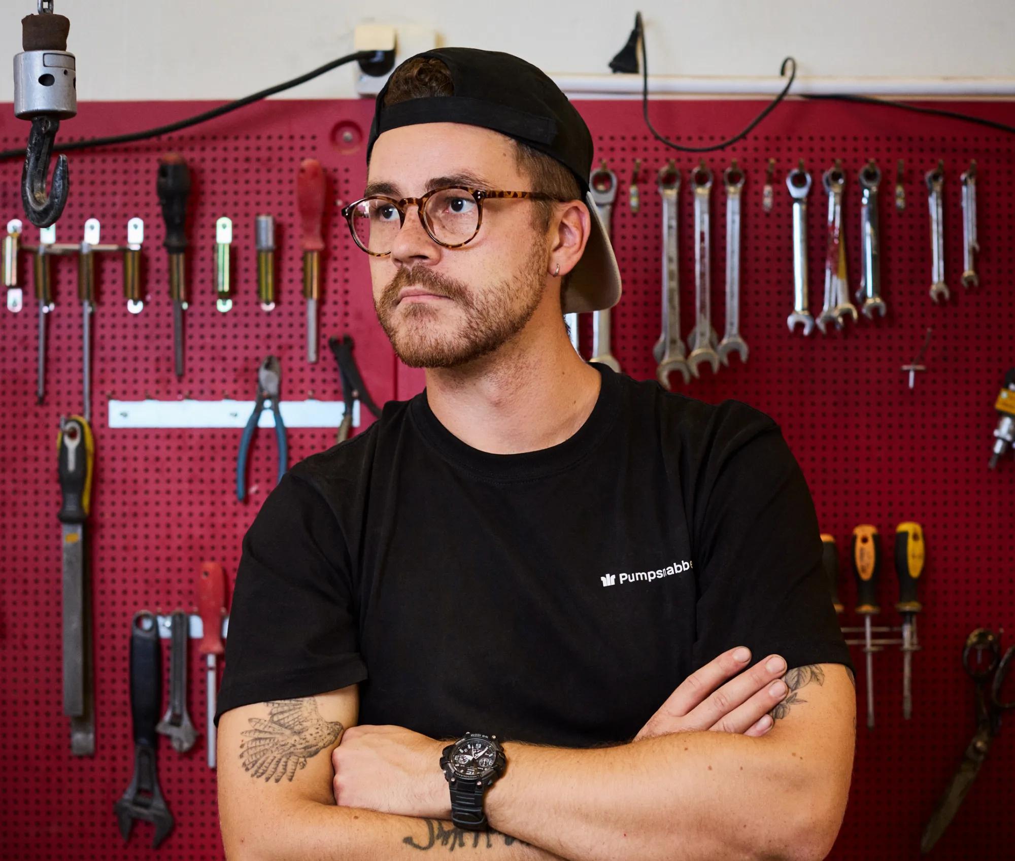 Arbetare bakom men vägg av verktyg